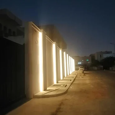 Warm vertical architectural lighting along an exterior wall at night
